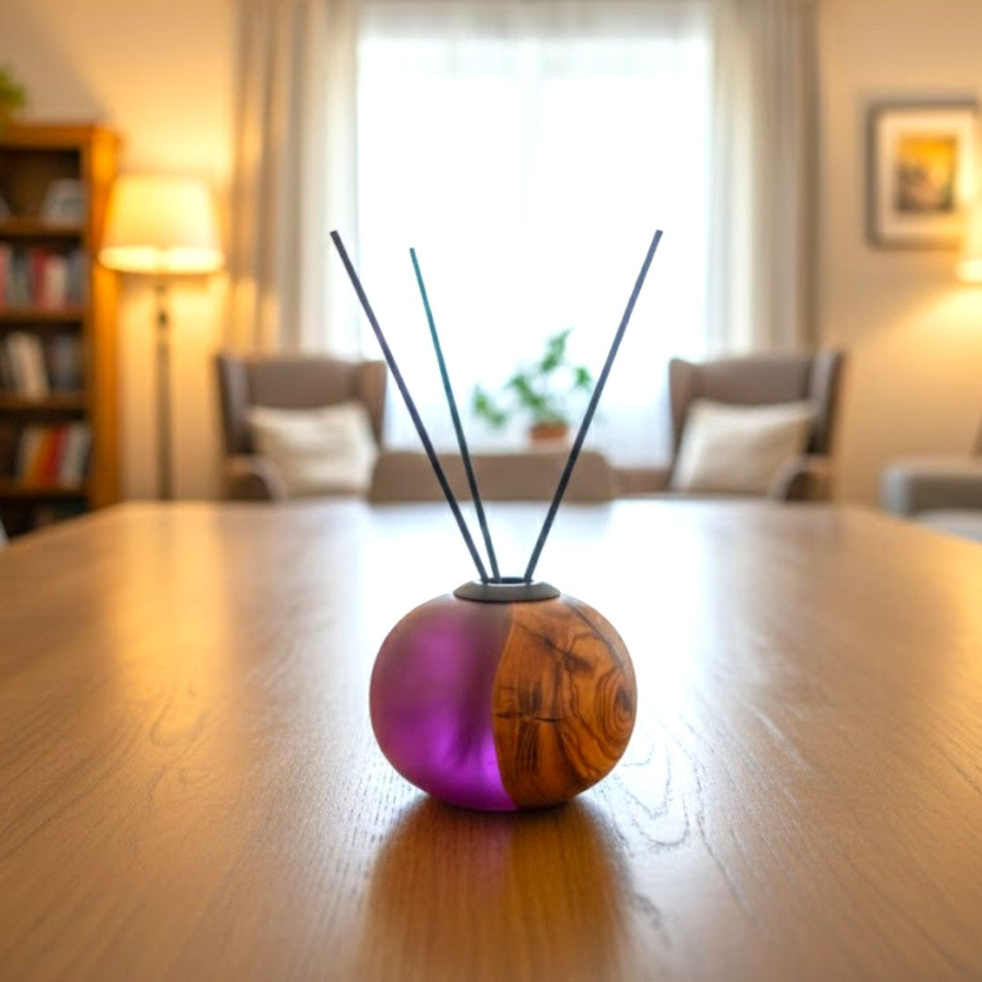 Ronde geurstokhouder van olijfhout met paarse epoxy op een houten tafel in een woonkamer